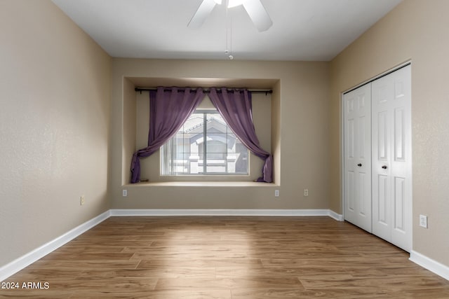 unfurnished bedroom featuring light hardwood / wood-style flooring, ceiling fan, and a closet