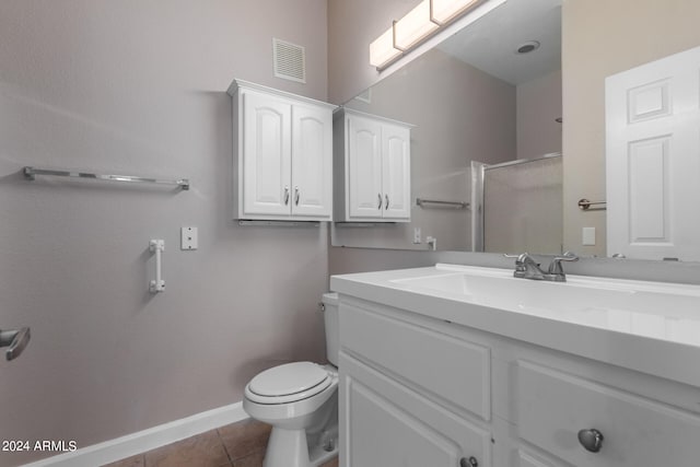 bathroom featuring vanity with extensive cabinet space, toilet, and tile floors