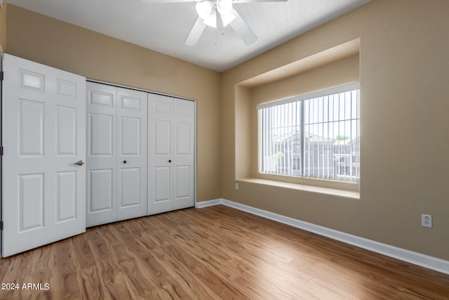 unfurnished bedroom featuring a closet, light hardwood / wood-style flooring, and ceiling fan