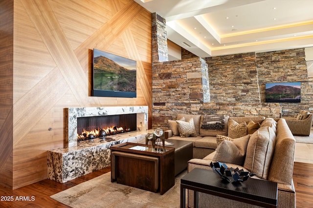 living room with wooden walls, a fireplace, and wood-type flooring