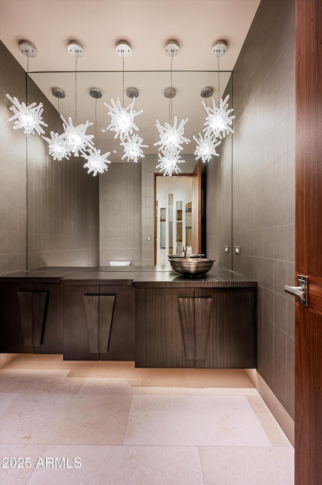 bathroom featuring vanity, tile patterned floors, and tile walls