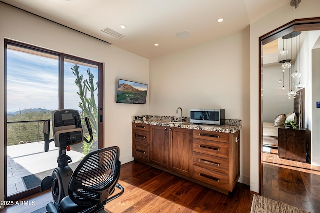 home office with dark hardwood / wood-style floors and sink