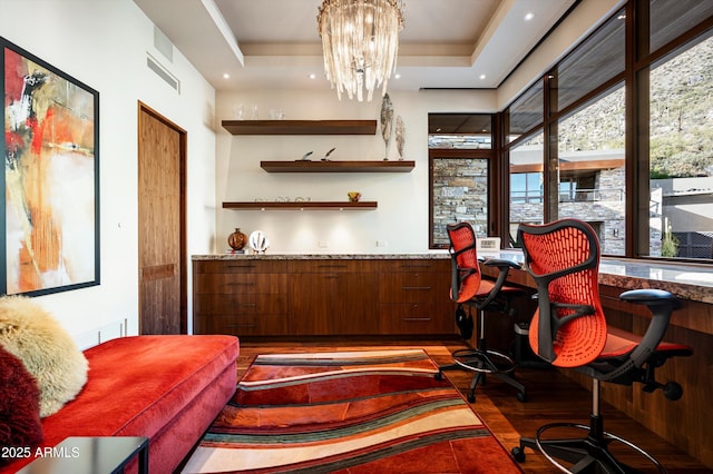 bar with a tray ceiling and a chandelier