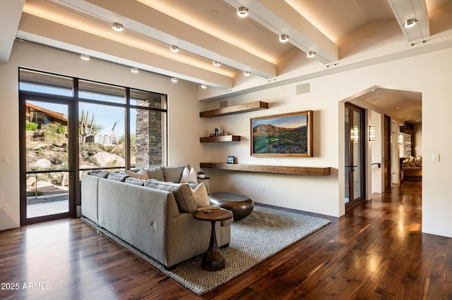 living room featuring beamed ceiling, rail lighting, and dark wood-type flooring