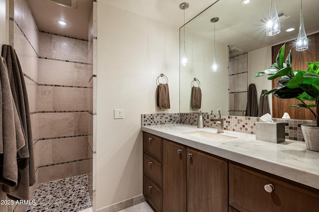 bathroom featuring a shower, vanity, and tasteful backsplash