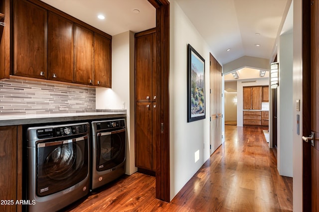 washroom with cabinets, dark hardwood / wood-style flooring, and washer and clothes dryer