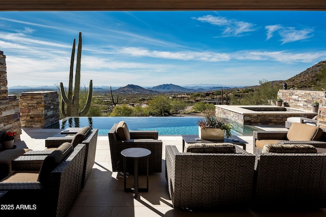 view of pool featuring outdoor lounge area, a mountain view, a patio area, and an in ground hot tub