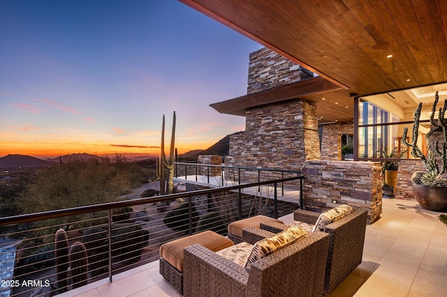 balcony at dusk with an outdoor living space and a mountain view