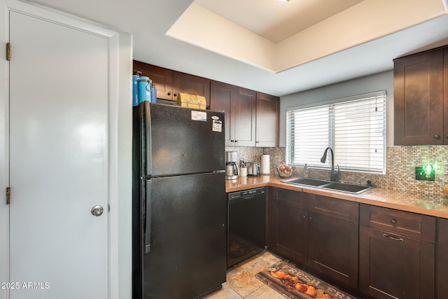 kitchen with dark brown cabinetry, sink, a tray ceiling, decorative backsplash, and black appliances