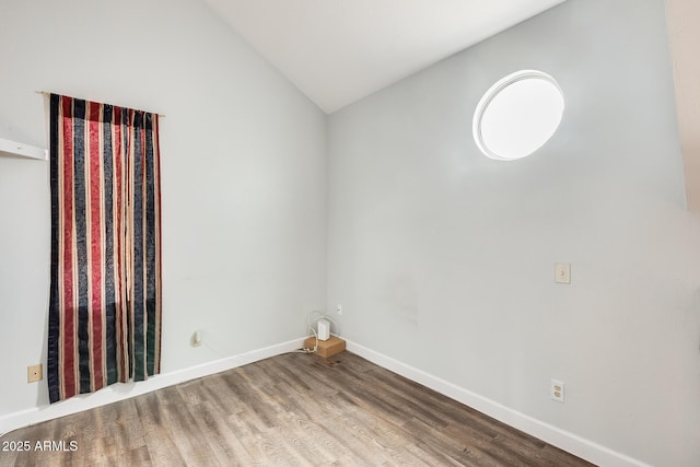 unfurnished room featuring vaulted ceiling and hardwood / wood-style floors