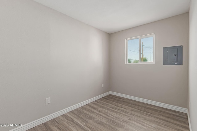 spare room featuring light hardwood / wood-style flooring and electric panel