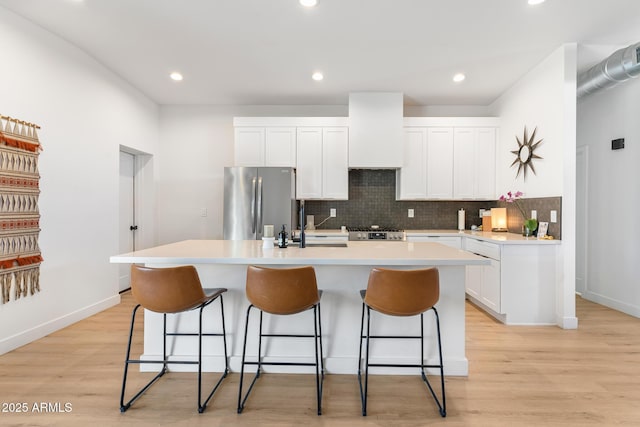 1212 E Indianola Ave, Phoenix, AZ 85014 - kitchen with a center island with sink, baseboards, freestanding refrigerator, decorative backsplash, and range
