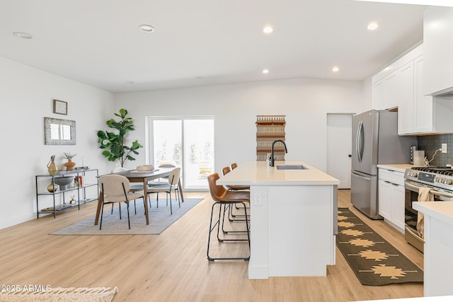 1212 E Indianola Ave, Phoenix, AZ 85014 - kitchen featuring tasteful backsplash, a sink, an island with sink, light countertops, and appliances with stainless steel finishes
