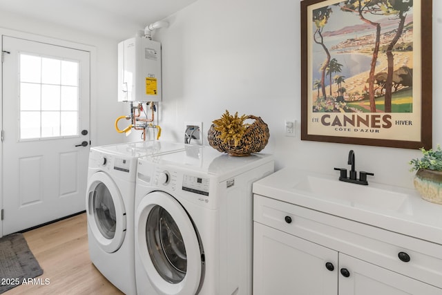 1212 E Indianola Ave, Phoenix, AZ 85014 - laundry room with washing machine and clothes dryer, light wood-style flooring, a sink, water heater, and cabinet space