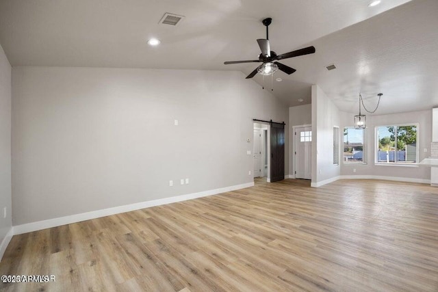 780 E Cobble Ln, Taylor, AZ 85939 - unfurnished living room with a barn door, ceiling fan, light wood-type flooring, lofted ceiling, and baseboards