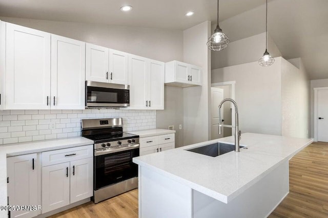 780 E Cobble Ln, Taylor, AZ 85939 - kitchen with stainless steel appliances, a sink, white cabinets, tasteful backsplash, and light wood finished floors