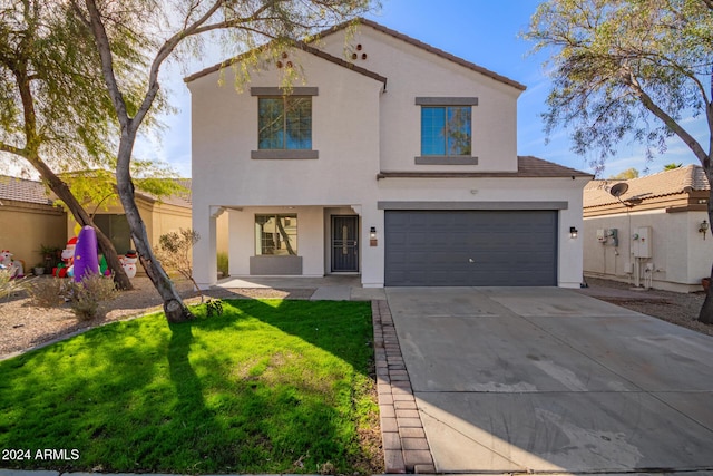 mediterranean / spanish home featuring a front yard and a garage