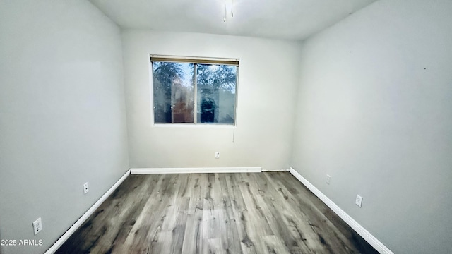 unfurnished room with baseboards and wood finished floors