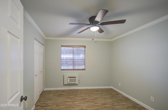 unfurnished bedroom with ornamental molding, heating unit, wood finished floors, a closet, and baseboards