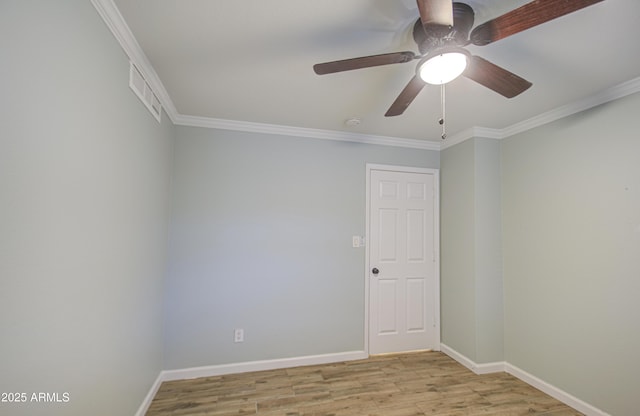 empty room with visible vents, light wood-style flooring, baseboards, and ornamental molding