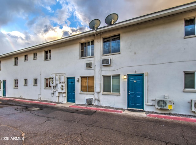 view of front of property featuring ac unit and stucco siding