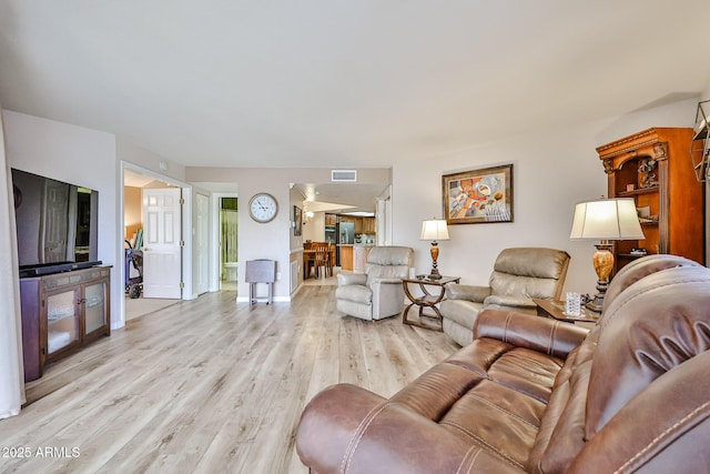 17404 N 99th Ave Unit 318, Sun City, AZ 85373 - living room featuring light wood-style floors, baseboards, and visible vents