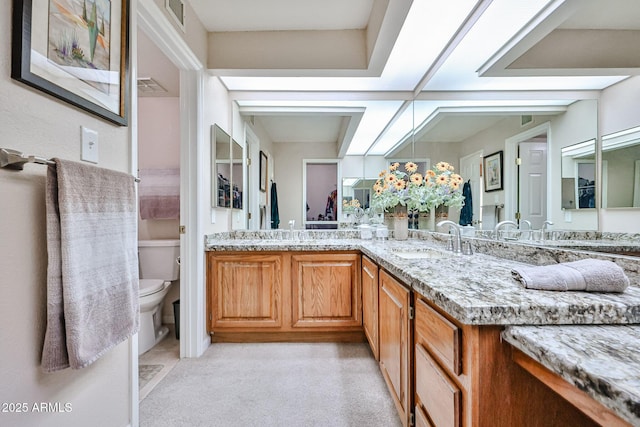 17404 N 99th Ave Unit 318, Sun City, AZ 85373 - bathroom with toilet, double vanity, a sink, and visible vents