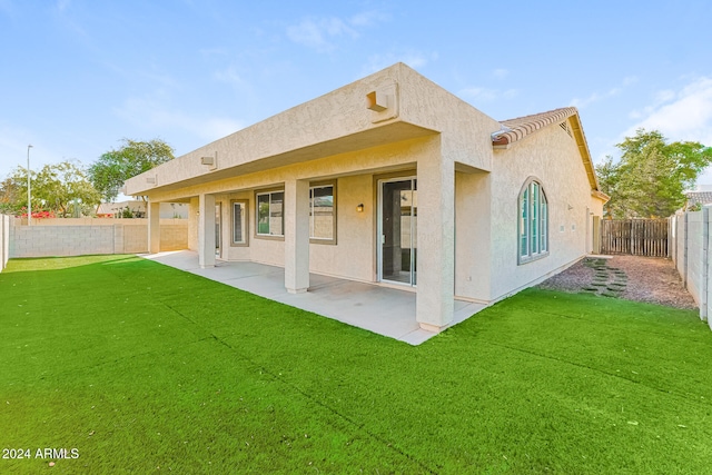 rear view of house with a yard and a patio