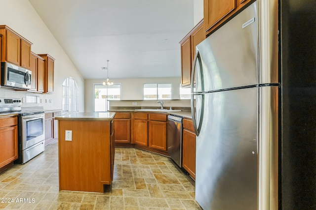 kitchen with pendant lighting, a center island, sink, vaulted ceiling, and stainless steel appliances