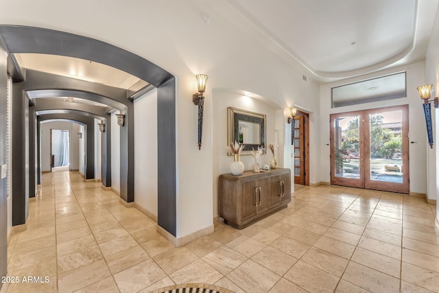 hallway with light tile patterned floors and french doors