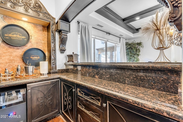 interior space featuring dark brown cabinets, light wood-type flooring, and dark stone counters