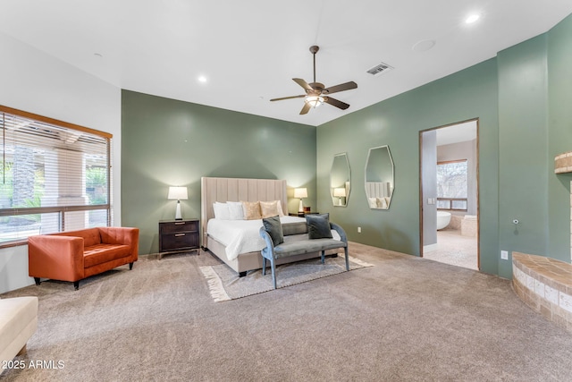 bedroom with light carpet, connected bathroom, and ceiling fan