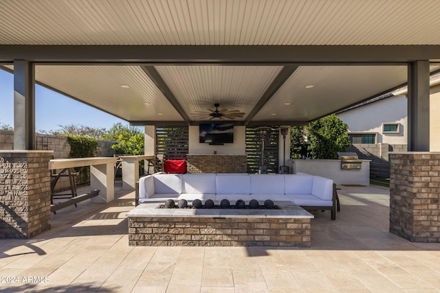 view of patio / terrace featuring an outdoor living space, an outdoor bar, ceiling fan, and exterior kitchen