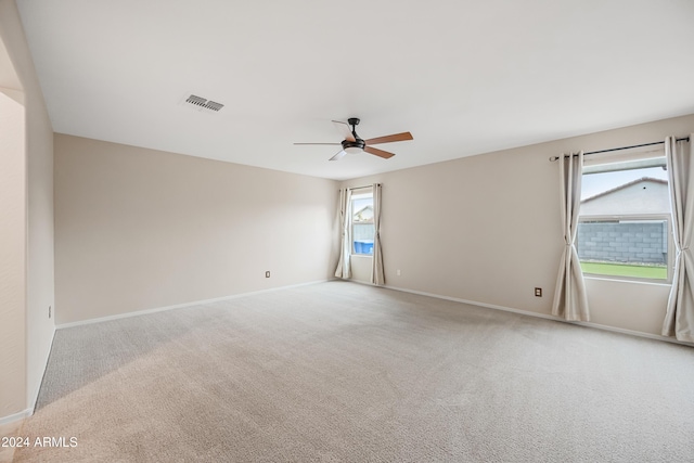 carpeted empty room featuring a wealth of natural light and ceiling fan