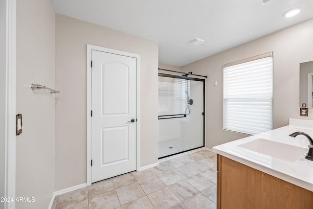 bathroom featuring tile patterned floors, vanity, and a shower with shower door