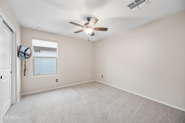 carpeted spare room featuring ceiling fan