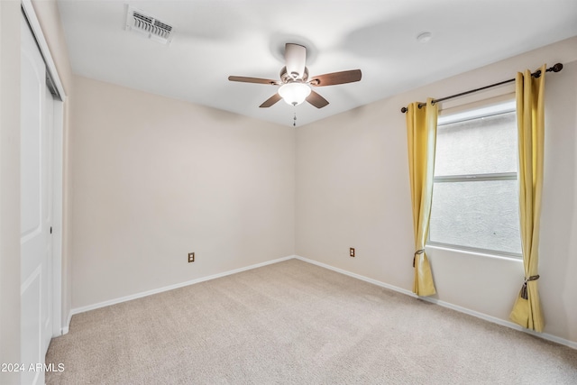 unfurnished room featuring light colored carpet and ceiling fan