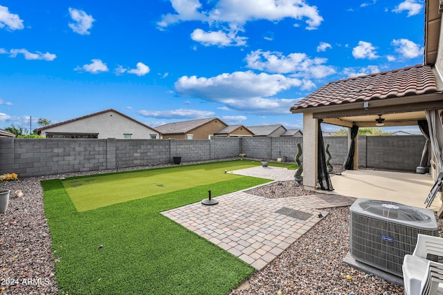 view of yard with ceiling fan, a patio area, and central air condition unit