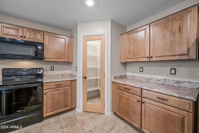 kitchen with black appliances, light stone counters, and light tile patterned floors