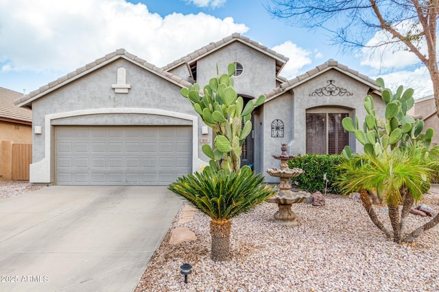 mediterranean / spanish house featuring driveway, a tile roof, a garage, and stucco siding