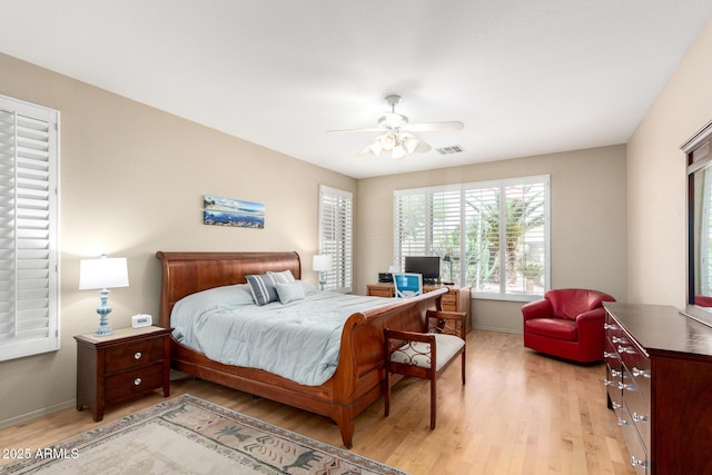 bedroom with light wood-style floors, baseboards, and a ceiling fan