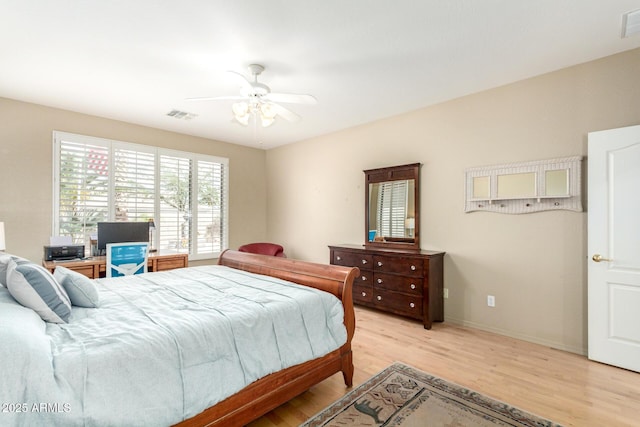 bedroom featuring light wood finished floors, baseboards, visible vents, and ceiling fan