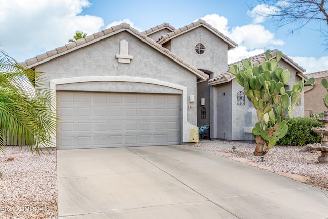 mediterranean / spanish-style home with a garage, concrete driveway, a tiled roof, and stucco siding