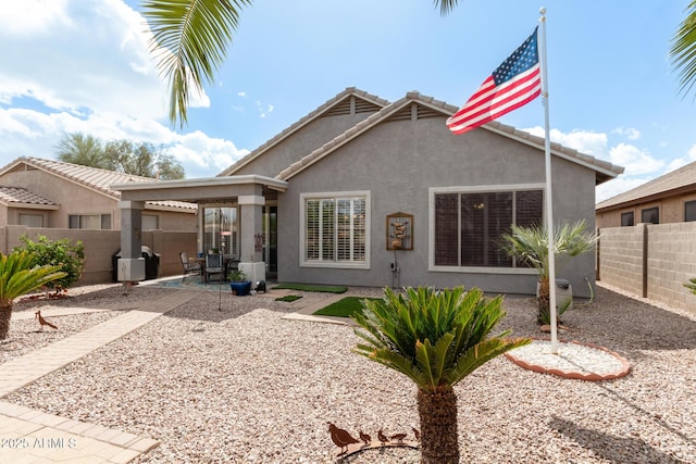 back of property featuring a patio area, a fenced backyard, a tiled roof, and stucco siding