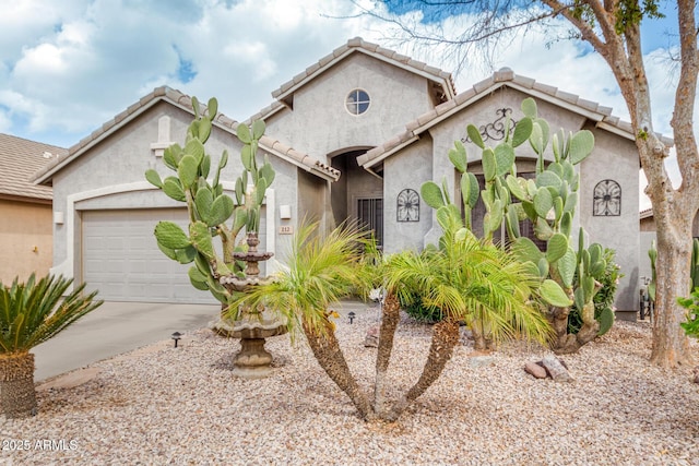 mediterranean / spanish house featuring a garage, concrete driveway, and stucco siding