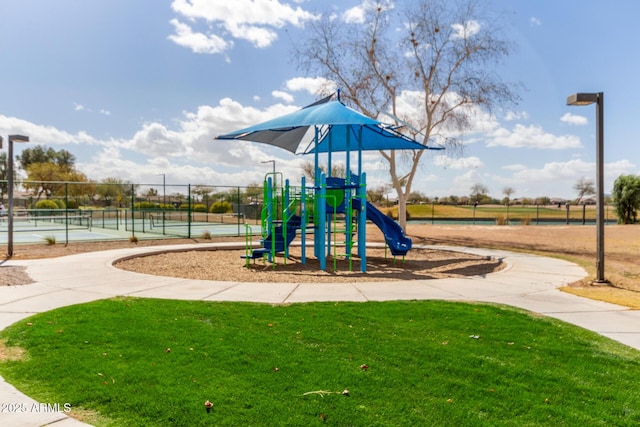 community playground featuring a yard and fence