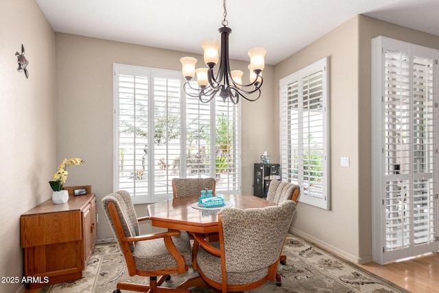 dining space featuring an inviting chandelier, plenty of natural light, and baseboards