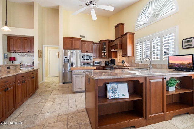 kitchen featuring open shelves, a towering ceiling, stone tile flooring, stainless steel appliances, and a sink