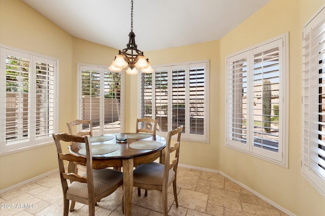 dining space featuring stone tile floors, a healthy amount of sunlight, and baseboards