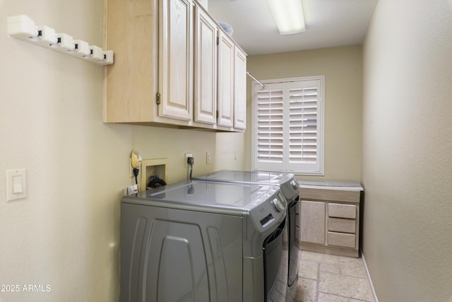 washroom with stone tile floors, washing machine and dryer, and cabinet space